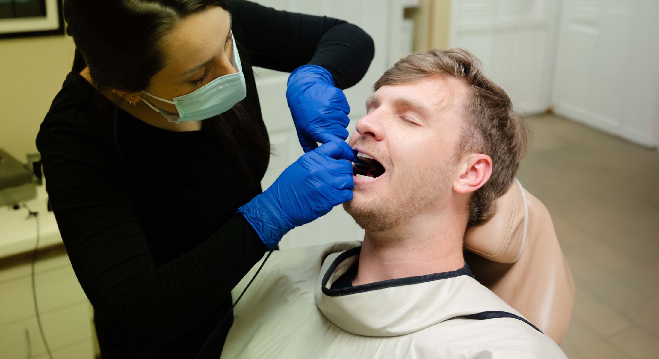 dental cleaning and exam patient model receiving treatment from a hygienist